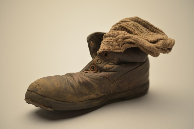 Zapato y calcetín de niño, colección del Museo Estatal de Auschwitz-Birkenau - Foto por Pawel Sawicki © Auschwitz-Birkenau State Museum - Musealia
